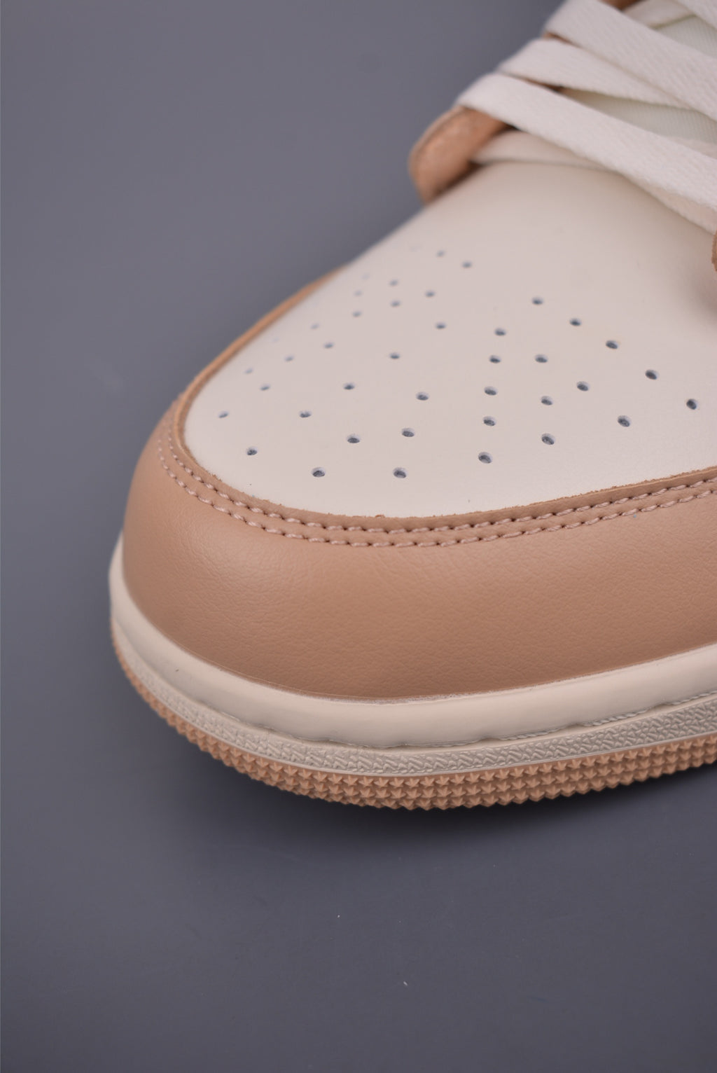 Air Jordan 1 Low Beige Orange con un fondo urbano, mostrando su estilo casual.