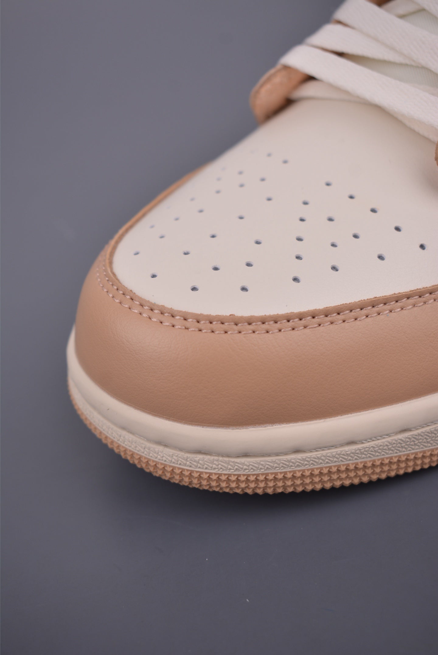 Air Jordan 1 Low Beige Orange con un fondo urbano, mostrando su estilo casual.