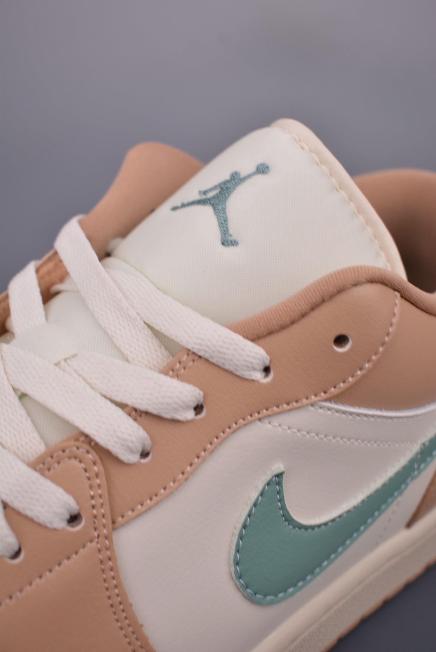 Vista trasera de las Air Jordan 1 Low Beige Orange destacando el logo y la estructura.