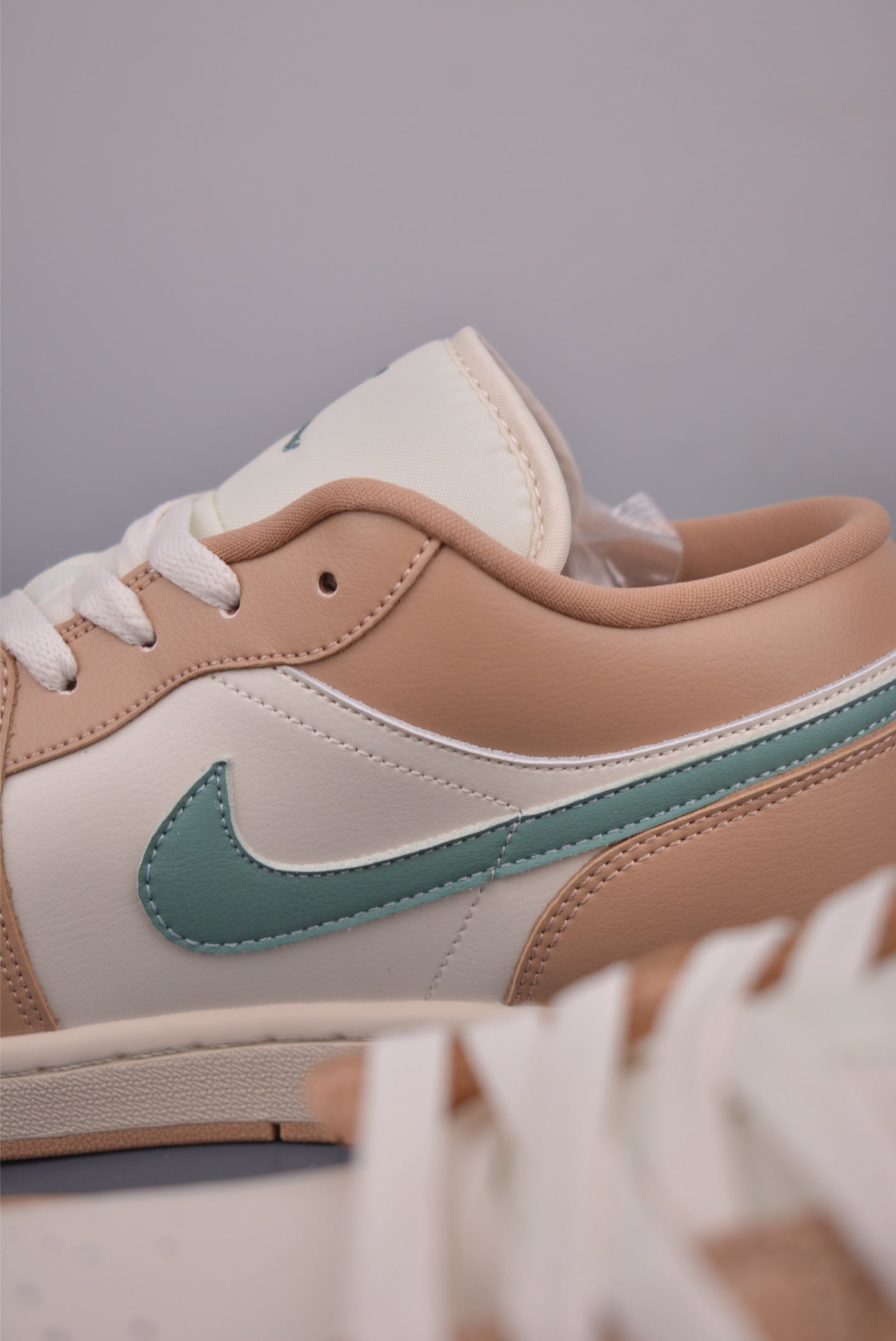 Air Jordan 1 Low Beige Orange lateralmente, resaltando sus características de diseño.